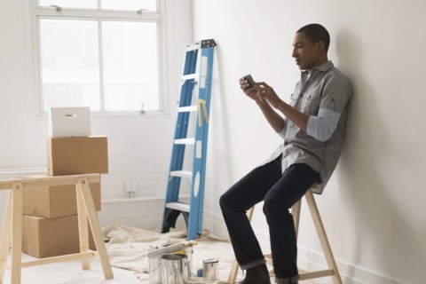 Black man sitting in room under renovation