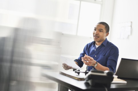 Black businessman talking at office desk