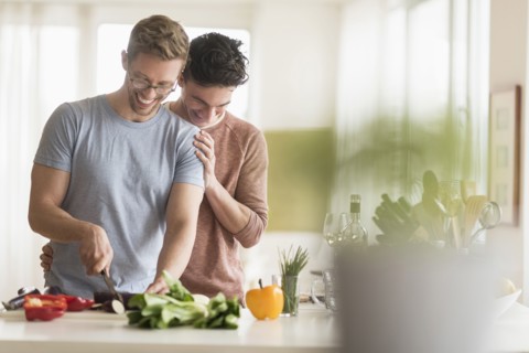 Caucasian gay couple cooking in kitchen