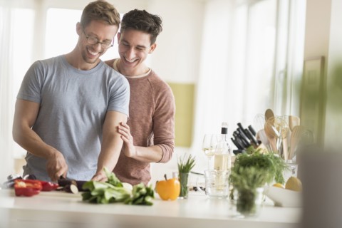 Caucasian gay couple cooking in kitchen