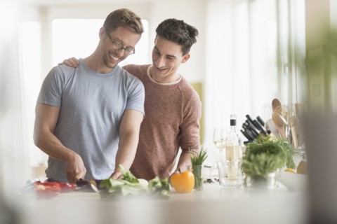 Caucasian gay couple cooking in kitchen