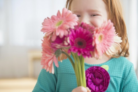 Caucasian girl holding bouquet of flowers