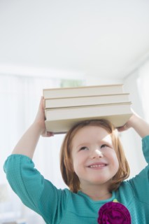 Caucasian girl balancing books on head