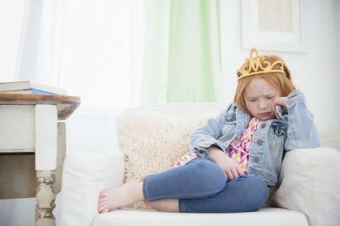 Upset Caucasian girl pouting in armchair