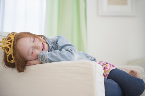 Caucasian girl wearing tiara in armchair