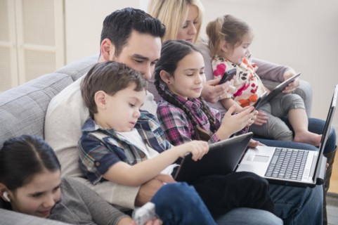 Caucasian family using technology on sofa