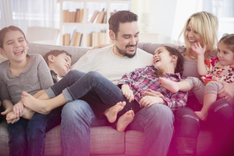 Caucasian family playing on sofa