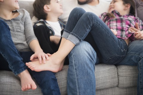 Caucasian father and children relaxing on sofa