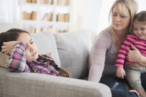 Caucasian mother comforting upset daughter on sofa