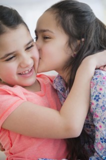 Close up of Caucasian sisters kissing