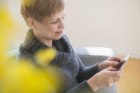 Caucasian woman using cell phone on sofa