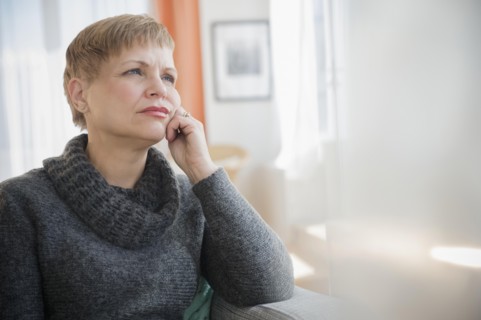 Anxious Caucasian woman sitting on sofa