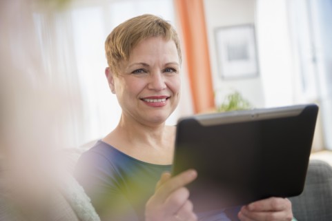 Caucasian woman using digital tablet on sofa
