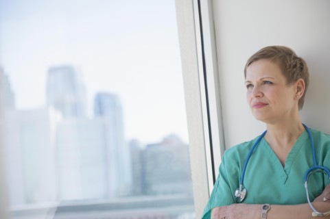 Caucasian nurse near window