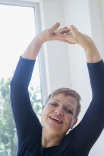 Caucasian woman stretching near window