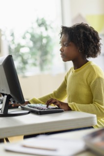 Black student using computer in classroom