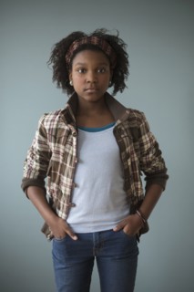 Stylish Black girl standing with hands in pockets