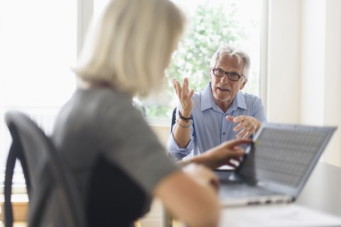 Older Caucasian business people arguing in office meeting