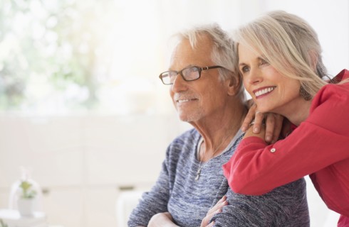 Older Caucasian couple hugging in living room