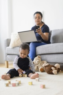 Mixed race mother and baby son relaxing in living room
