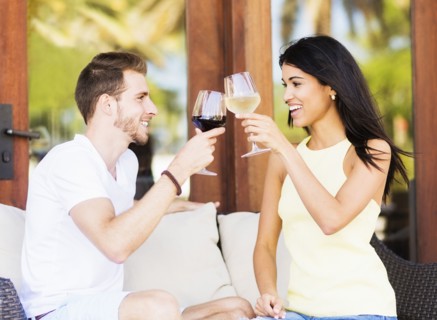 Hispanic couple toasting with wine