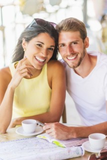 Hispanic couple reading map at cafe