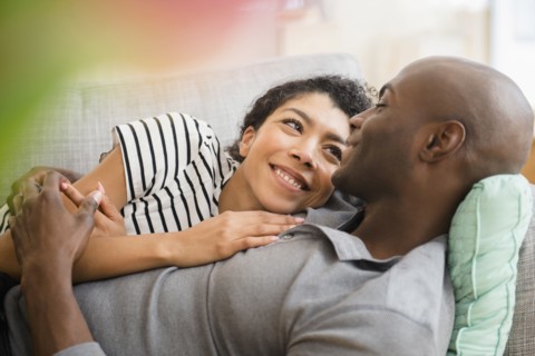 Smiling couple laying on sofa