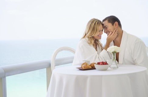 Couple eating breakfast on balcony