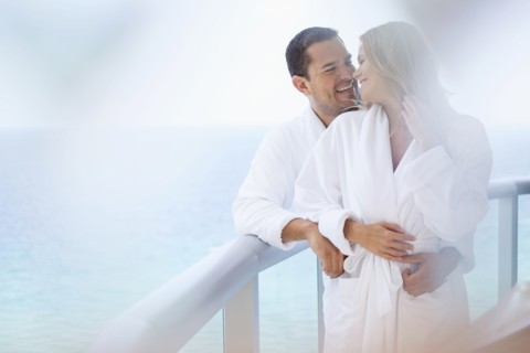 Couple hugging on balcony over ocean