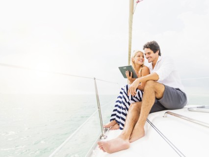 Couple using digital tablet boat deck
