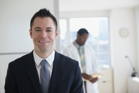 Businessman smiling in office with doctor