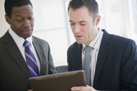 Businessmen using digital tablet in office