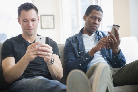 Men using cell phones on sofa