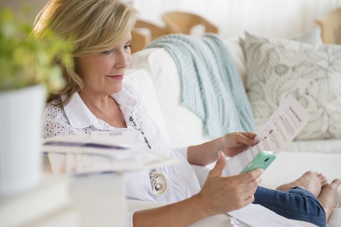 Caucasian woman paying bills online on cell phone