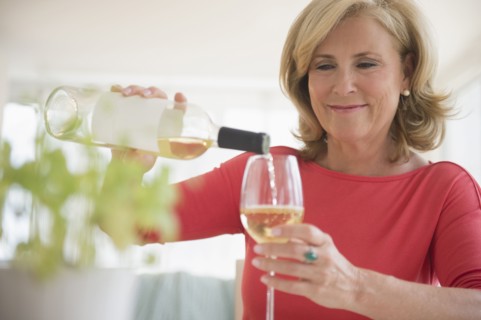 Caucasian woman pouring glass of white wine