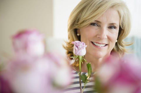 Caucasian woman holding pink rose