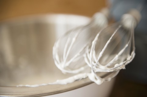 Close up of electric mixer whipping cream