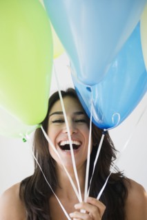 Close up of woman holding bunch of balloons