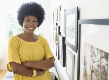 African American woman standing near pictures on wall