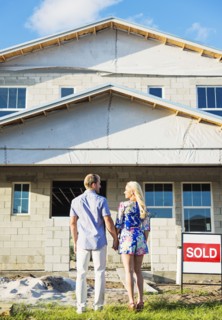 Caucasian couple admiring new home