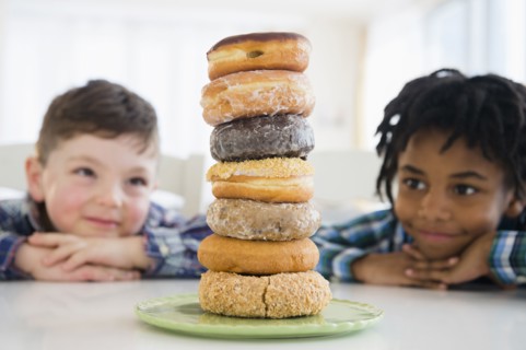 Boys admiring stack of donuts on counter