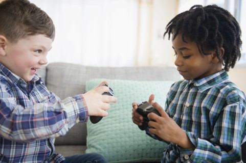 Boys playing video games on sofa