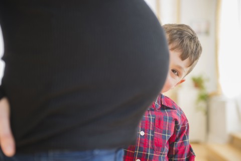 Boy admiring belly of pregnant mother