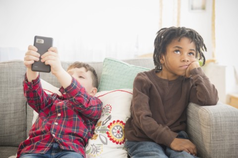 Boy with cell phone ignoring friend