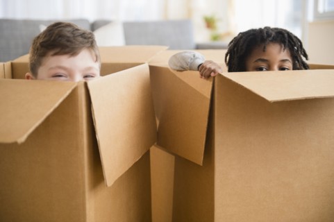 Close up of boys playing in cardboard boxes