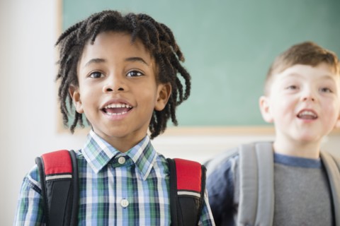 Students wearing backpacks in classroom