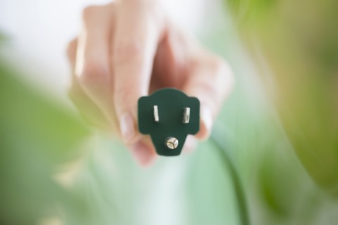 Mixed race woman holding electrical plug