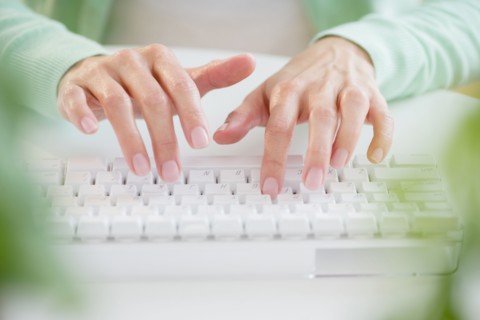 Mixed race woman typing on computer keyboard