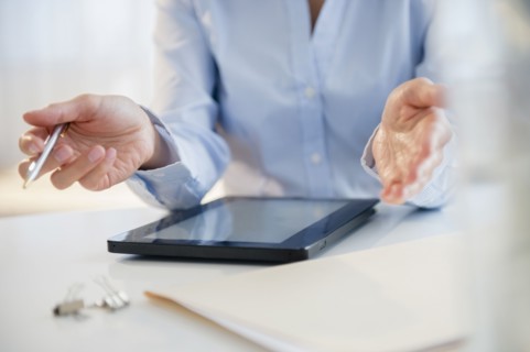 Mixed race businesswoman using digital tablet at desk