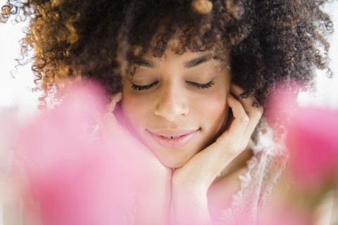 Mixed race woman resting chin in hands